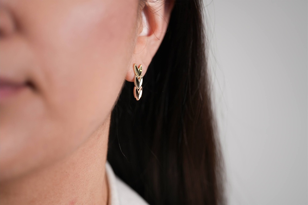 chevron tri color gold earrings on womans ear