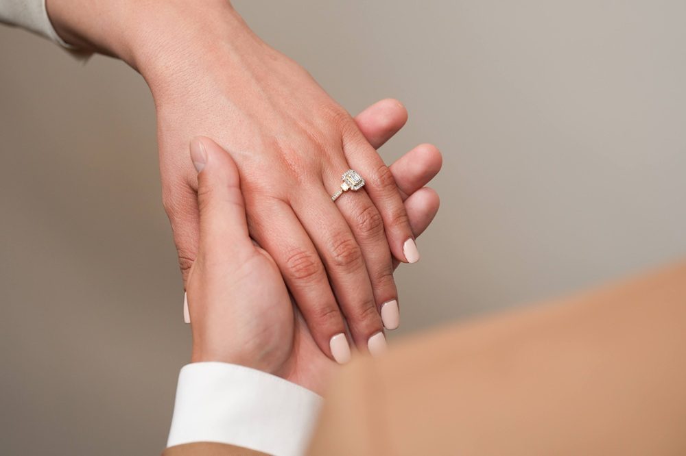 woman with engagement ring on holding hands with fiancee