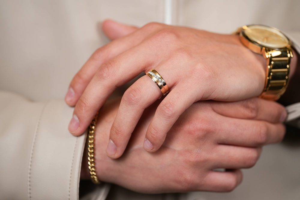 man wearing gold jewelry, watch, ring and bracelet